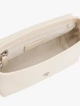Cartera compacta Tommy Jeans de color blanco marfil con acabado liso, cierre de solapa magnética y detalle de parche metálico con logo en la parte delantera. Cuenta con una correa tejida ajustable y extraíble, compartimento principal y bolsillo interior con cremallera.