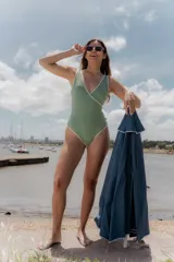 Malla enteriza de textura acanalada en color verde, con diseño cruzado tipo sobre y ribetes en color blanco. Presenta escote en V profundo y espalda descubierta.