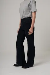 Jean de denim negro, tiro alto y corte recto, con costuras verticales decorativas en el frente.