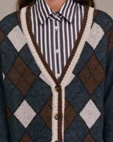 Cárdigan con estampado de rombos en tonos marrón, beige y azul, con cuello en V y cierre frontal con botones. Mangas largas y ribete acanalado en puños y bajo.