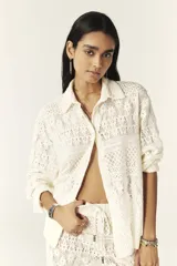 Camisa color blanco hueso con cuello clásico, tapeta con botones en la parte delantera y corte recto ligeramente oversize. Diseño con acabado de encaje.