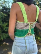 Top corto tejido de punto a crochet, sin mangas, con diseño multicolor en celeste, beige y azul, y aberturas frontales estratégicas tipo cut-out.