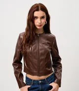 Campera de cuero sintético color marrón, con cuello redondo, cierre frontal y bolsillos laterales con cremallera. Presenta costuras verticales decorativas que le dan un diseño estructurado.