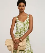 Musculosa femenina confeccionada en una mezcla de viscosa y lino, con estampado de follaje verde sobre fondo crudo. Presenta un cuello en V y breteles anchos con detalle fruncido, ofreciendo un calce regular y fluido.