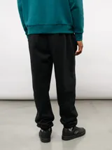 Pantalón de jogging de felpa con friza, color gris, con cintura elástica, bolsillos laterales y puños en los tobillos. Presenta un parche con el logo de Umbro en la parte superior delantera.