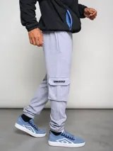 Pantalón cargo gris melange de algodón, poliéster y elastano, con bolsillos laterales tipo parche en las piernas y puños ajustados en los tobillos.