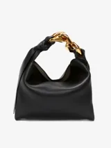 Bolso de mano JW Anderson modelo Chain Hobo Small, color negro, confeccionado en cuero. Presenta cierre magnético, logo en relieve, asa con cadena decorativa en tono dorado y un compartimento interno.