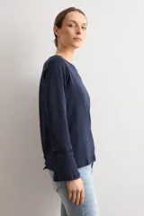 Remera de manga larga color azul marino, con cuello redondo y detalle de puntilla en los puños.
