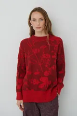 Buzo de tejido de punto con cuello redondo, mangas largas con puños acanalados y diseño estampado de flores en tonos rojos.