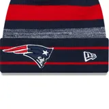 Gorro de lana New Era con pompón, con el logo de los New England Patriots y el logo de la NFL bordados. Diseño a rayas horizontales en azul marino, rojo y gris.