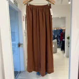 Pantalón tostado de corte ancho y relajado, con cintura elástica fruncida y bolsillos laterales.