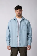 Chaqueta de jean celeste de corte recto, con cuello clásico, cierre frontal con botones metálicos y bolsillo de parche en el pecho.