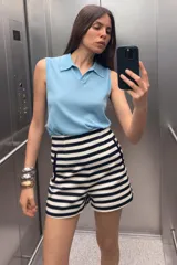 Bermuda de tiro alto con estampado de rayas horizontales en blanco y azul marino. Tiene bolsillos delanteros de vivo y cierre lateral con cremallera oculta en la costura.