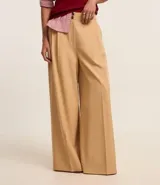 Pantalón pantalona negro de sastrería con pliegues delanteros y cintura sencilla con botón.