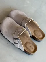 Zuecos color beige con hebilla metálica ajustable, plantilla anatómica de corcho y suela de goma.