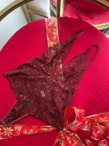 Body de encaje bordó con escote profundo en V, breteles regulables y diseño entallado.