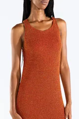 Vestido midi sin mangas de punto jersey con hilo Lurex en tono naranja cobrizo y destellos brillantes. Presenta escote bote y aberturas laterales.
