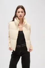 Campera híbrida con cuerpo delantero acolchado tipo puffer y mangas de tejido de punto acanalado con cuello alto. Presenta un diseño corto y holgado con cierre frontal oculto.