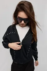 Campera tostada de calce relajado con capucha, cierre frontal, bolsillos laterales y detalles de tachas metálicas.