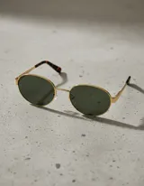 Lentes de sol ovalados con montura delgada dorada y patillas gruesas con estampado carey. Lentes polarizadas verdes con protección UV400.