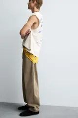 Camiseta tipo tank (sin mangas) de corte relajado, color blanco roto con efecto lavado. Presenta un estampado frontal en azul con texto en francés: "Coquillages Grillés De Côte-Marine" y "Salty Shack".