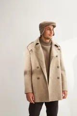 Saco de lana color tostado, con solapa, doble abotonadura, bolsillos, canesú y charreteras. Prenda de uso diario.