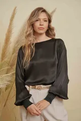 Blusa de satén color champagne con cuello a la base, mangas anchas y puños elásticos con detalle bordado.