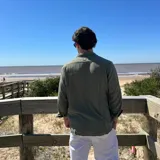 Camisa de manga larga color beige claro, con textura de lino arrugado y corte boxy. Presenta cuello camisero y cierre frontal de botones.