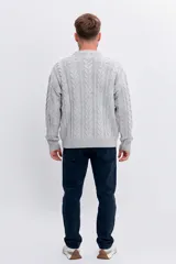 Sweater de punto con diseño de trenzas verticales, cuello redondo y puños acanalados.