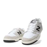 Championes New Balance 480 Court de estilo retro inspirado en el básquet, con exterior de cuero blanco y refuerzos de gamuza en tono gris claro. Presenta el logo N en color negro en los laterales, cordones blancos y suela de goma con base negra.