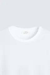 Camiseta de corte regular confeccionada en tejido de algodón compacto, con cuello redondo y manga corta.