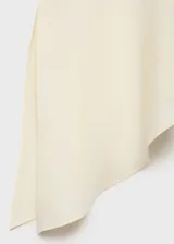 Top blanco de tejido fluido con cuello en V, tirantes anchos y bajo asimétrico con aberturas laterales.