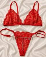 Conjunto de lencería de encaje color rojo, compuesto por un bralette triangular y una tanga con tiras regulables y una cadena plateada con dijes colgantes que forman la frase "TE AMO".