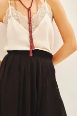 Falda corta negra con diseño de tablas y cintura elástica con detalle de fruncido.