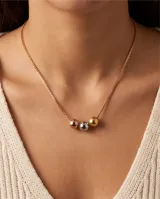 Collar de cadena veneciana de acero con baño dorado, decorado con tres dijes centrales en forma de esfera en tonos oro, plata y oro rosado.