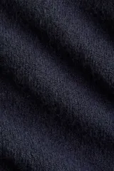 Buzo azul marino de punto suave con lana, corte entallado, cuello camisero, tapeta de botones y remate acanalado en puños y bajo.