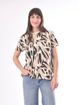 Remera blanca con estampado abstracto en color marrón.