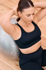 Top deportivo negro sin mangas con escote redondo y tiras entrelazadas en la espalda. Incluye copas desmontables.