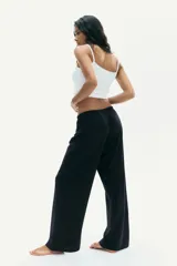 Pantalón negro de punto suave, corte holgado y pierna recta, con cintura elástica y cordón ajustable.