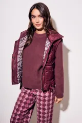 Chaleco bordeaux con interior estampado floral, de corte al cuerpo y cierre frontal con cremallera.