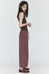 Pantalón de tiro medio con corte estilo balloon, cintura elástica ajustable con cordones, bolsillos laterales ocultos y bolsillos de plastrón en la parte trasera.