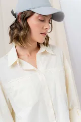 Gorra verde militar de diseño clásico con visera curva y aplique metálico plateado con la inscripción "Peach" en el lateral frontal. Cuenta con tira ajustable en la parte trasera.