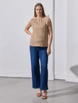 Blusa color beige con textura acanalada, cuello alto con detalle de crochet y volados en los hombros.