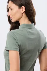Remera polo de piqué color rosado, con mangas cortas, cuello clásico y cierre frontal de botones.