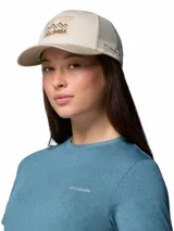 Gorro tipo trucker Columbia Mesh Snap Back de color beige, con visera curva en tono tostado, paneles traseros de malla transpirable y un parche frontal bordado con diseño de montañas y el logotipo de la marca.
