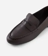 Mocasín femenino estilo penny loafer confeccionado en cuero, con suela baja y diseño estructurado con recorte en el empeine.