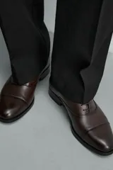 Zapato tipo oxford de vestir en color marrón oscuro, con diseño de puntera reforzada y cordones al tono.