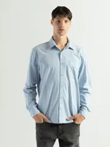 Camisa de manga larga color gris oscuro, confeccionada en algodón, con cuello clásico, cierre frontal con botones, bolsillo de parche en el pecho y corte clásico.