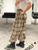 Pantalón tipo balloon de tejido plano con calce relajado, cintura elastizada y estampado cuadrillé en tonos marrones y beige.