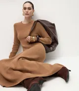 Vestido midi de punto con cuello redondo, mangas largas y falda evasé. Confeccionado en tejido de viscosa, poliéster y poliamida.
